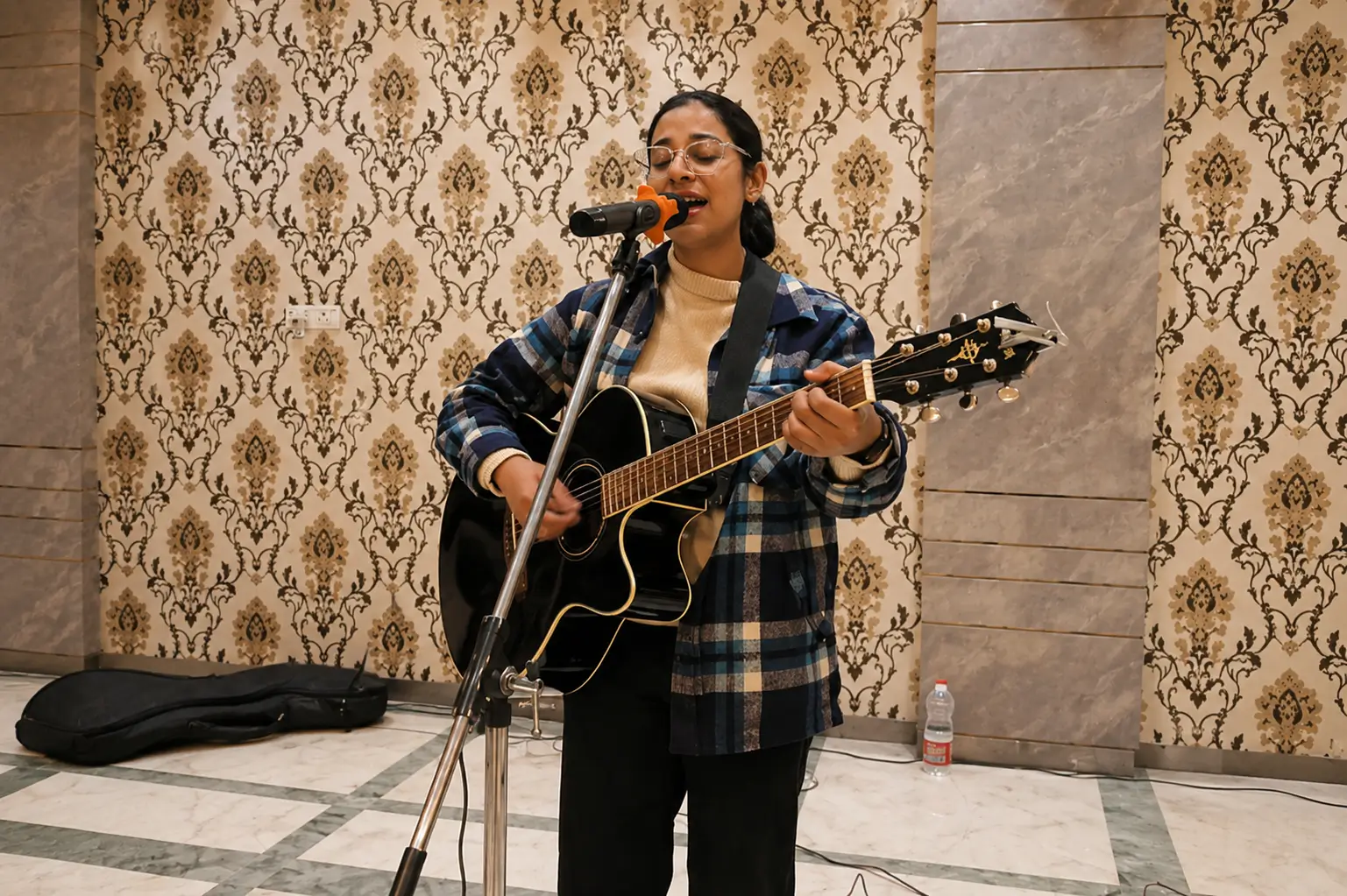 Female live singer performing with guitar at a wedding and event venue in Shimla