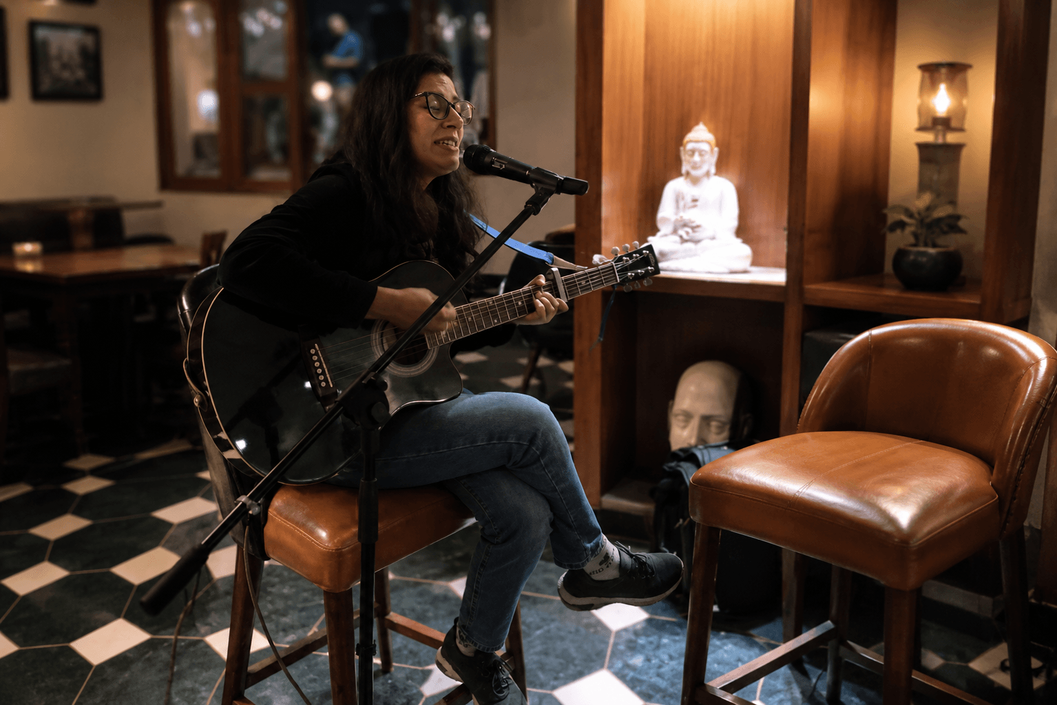 Professional female singer performing live guitar music during an intimate event in Shimla