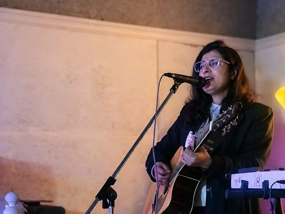 Live female singer performing at a private event in Shimla with acoustic guitar