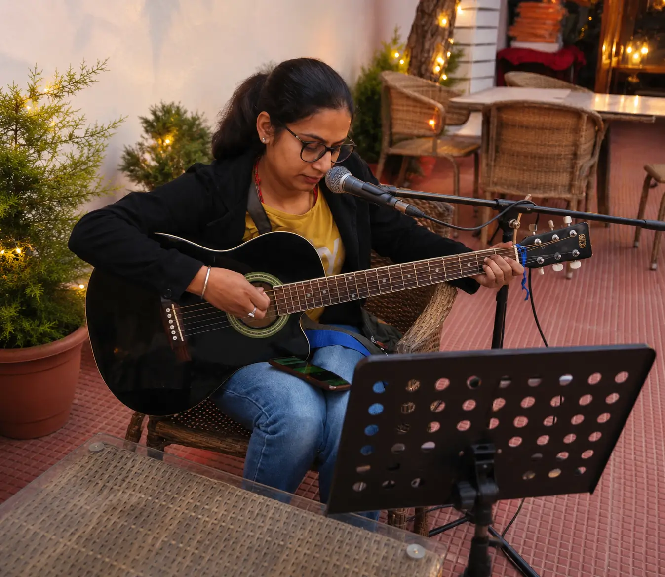 Female wedding singer performing live with acoustic guitar during an elegant wedding celebration in Himachal Pradesh, creating memorable moments through live music.